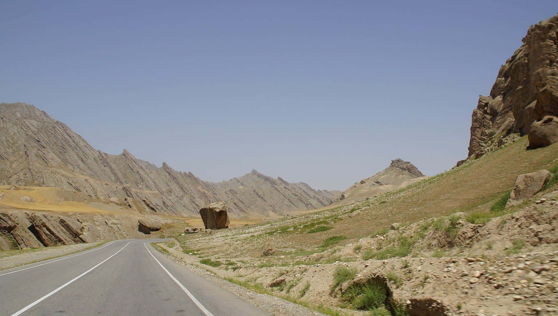 A paved road winding between rocky hills in northern Afghanistan