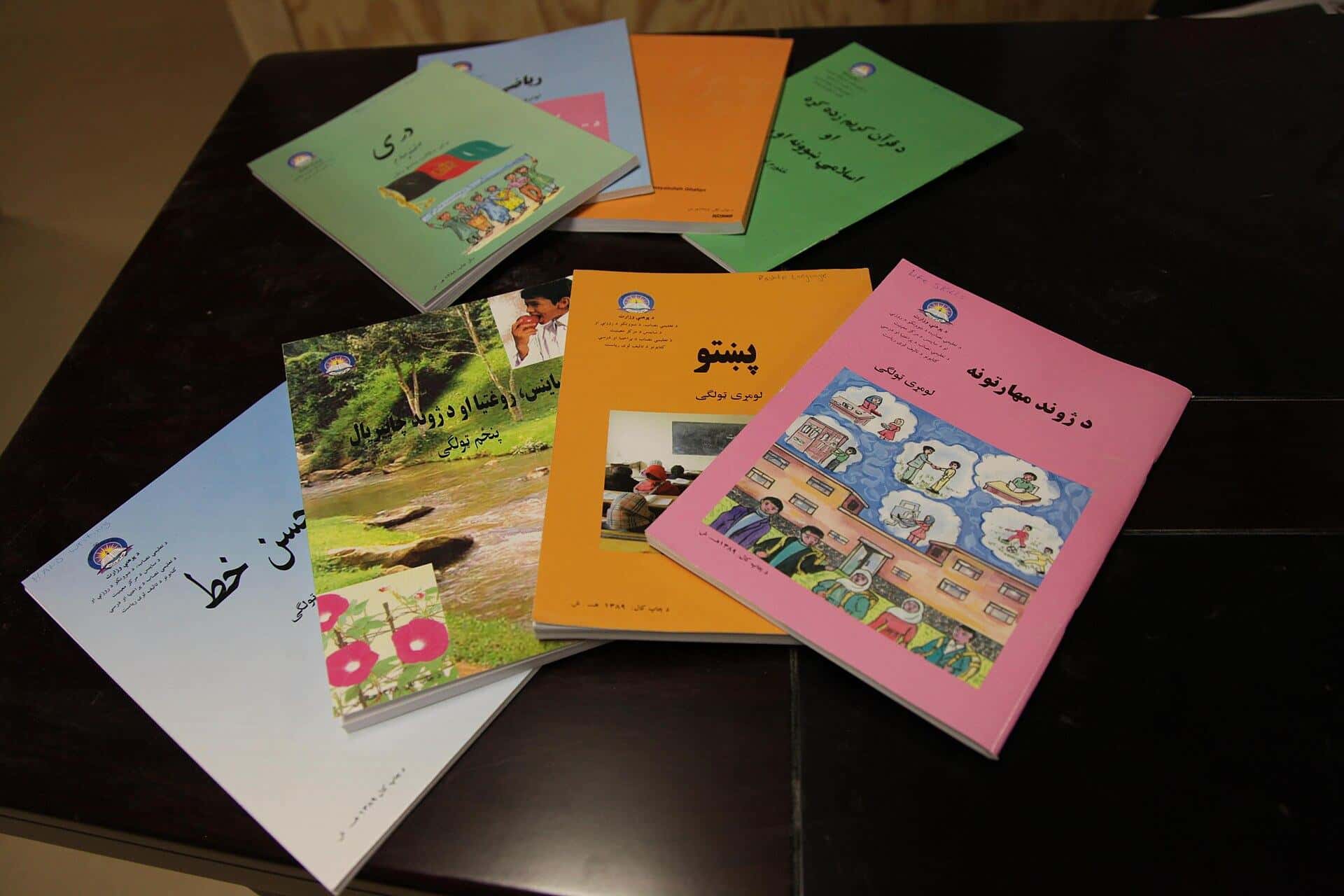 Primary school textbooks in Pashto spread on a table